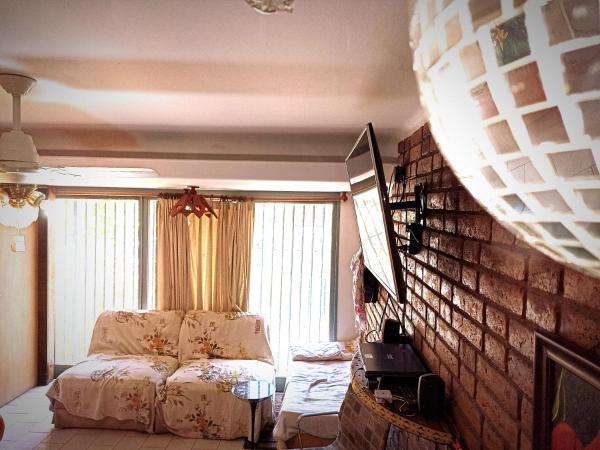 sala de estar con cama y pared de ladrillo en HABITACIÓN C AMPLIA COMPARTIDA en Mendoza