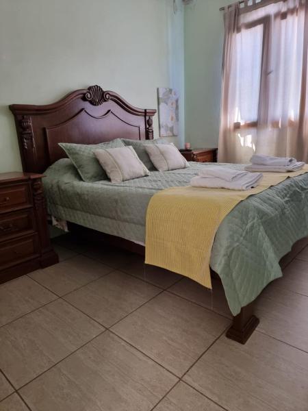 Un dormitorio con una cama con una manta amarilla. en HOSTERIA CAROL en Salta