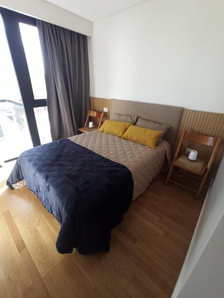 1 dormitorio con cama y ventana grande en Departamento impecable en Mar del Plata