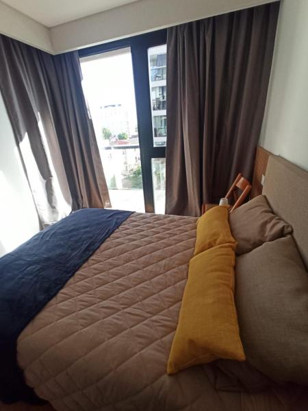 1 cama grande en un dormitorio con ventana en Departamento impecable en Mar del Plata