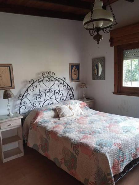 1 dormitorio con cama, ventana y lámpara en Villa Cristina en Chascomús