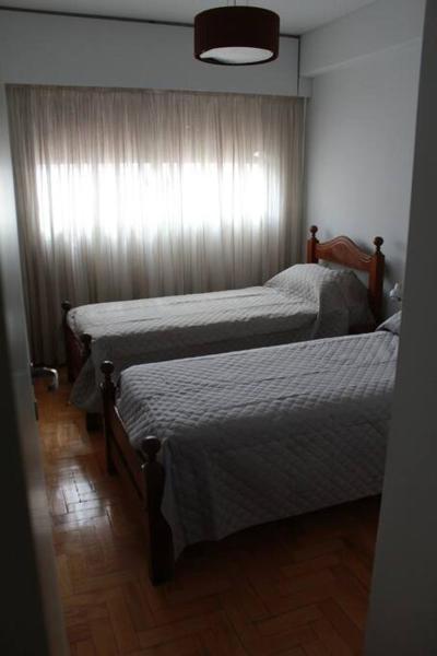 2 camas individuales en una habitación con ventana en Departamento Peatonal Sarmiento en Mendoza