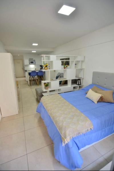 1 dormitorio con 1 cama azul y sala de estar en Departamento ideal para tu paso por Buenos Aires en Buenos Aires