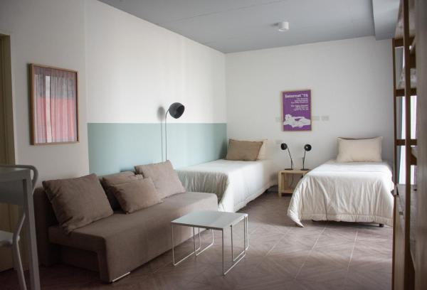 sala de estar con sofá y 2 camas en Casa Campus Palermo Cabrera en Buenos Aires