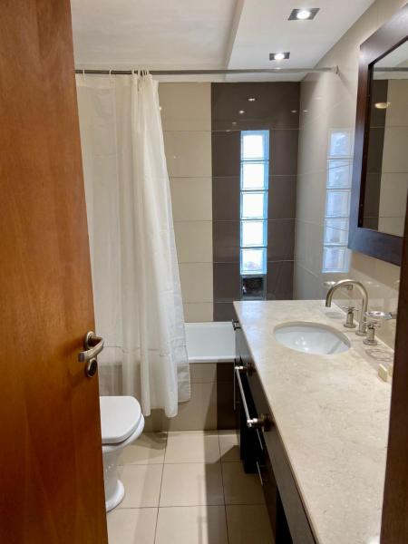 baño con cortina de ducha blanca y lavamanos en Departamentos de Categoría, Santa Fé y Alberti en Mar del Plata