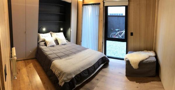 1 dormitorio con cama grande y ventana grande en Vivero 5, departamento 5 en San Martín de los Andes