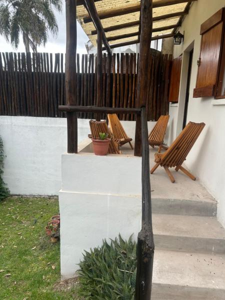 dos bancos sentados en un porche con una valla en Rincón Natural Urbano en San Salvador de Jujuy