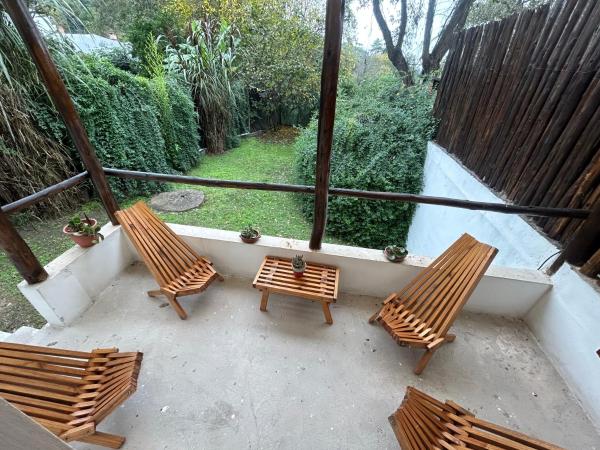 3 bancos de madera sentados en un balcón con vistas en Rincón Natural Urbano en San Salvador de Jujuy