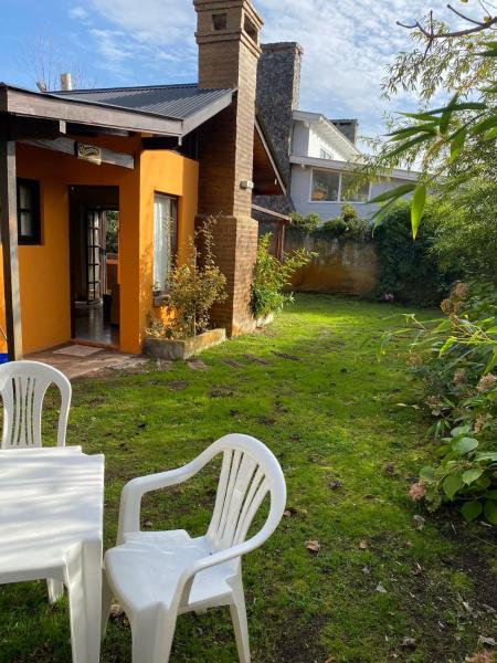 dos sillas blancas sentadas en el patio de una casa en El Quincho en Costa del Este