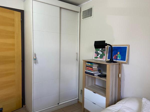1 dormitorio con armario blanco y estantería de libros en Bohemian Flat en Mendoza