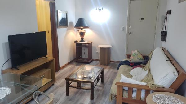 sala de estar con sofá y Tv LED en Calido y comodo 2 amb y medio zona Torreon en Mar del Plata