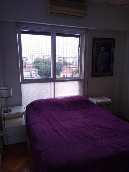 1 dormitorio con cama morada y ventana en Depto en Palermo, 2 ambientes muy luminoso con doble circulación, lavadero y balcón en Buenos Aires