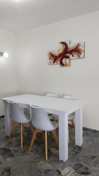 una mesa blanca con sillas y una pintura en la pared en DEPARTAMENTOS MENDOZA PEATONAL 2 en Mendoza