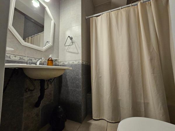 y baño con cortina de ducha y lavamanos. en En el Centro en Salta