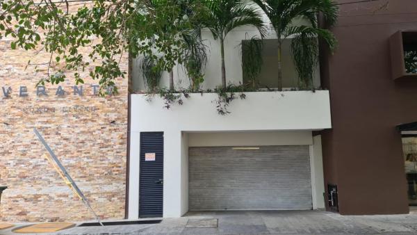 un edificio con una puerta de garaje y un árbol en MODERN AND DELIGHTFUL 1BR APARTMENT LOCATED IN DOWNTOWN., en Playa del Carmen