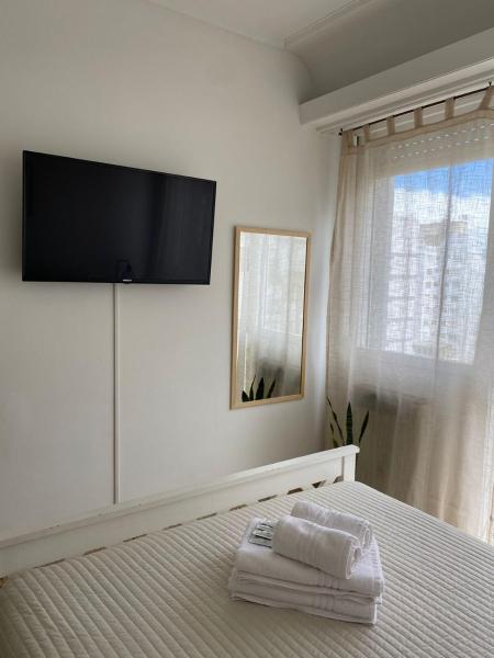 1 dormitorio con 1 cama y Tv LED en la pared en Alojamiento Calma en Mar del Plata