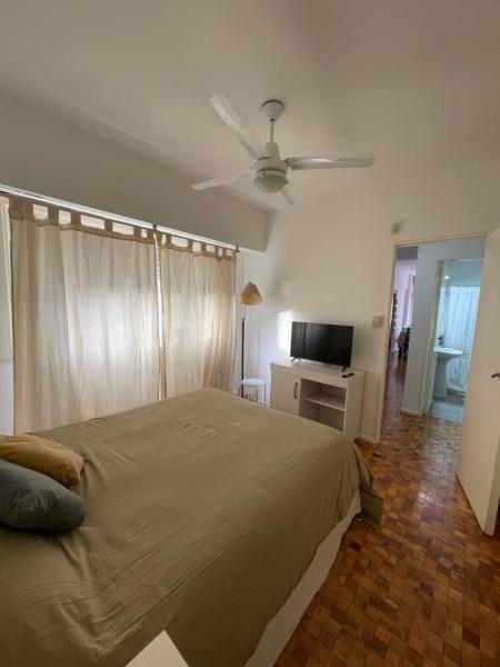 1 dormitorio con 1 cama y ventilador de techo en Depto cómodo en Pleno Centro Porteño en Buenos Aires