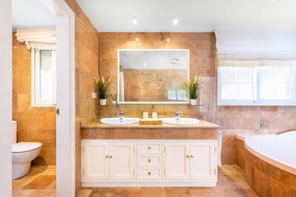 y baño con 2 lavabos, bañera y aseo. en Spectacular Two Floor Penthouse Marbella City Centre, en Marbella