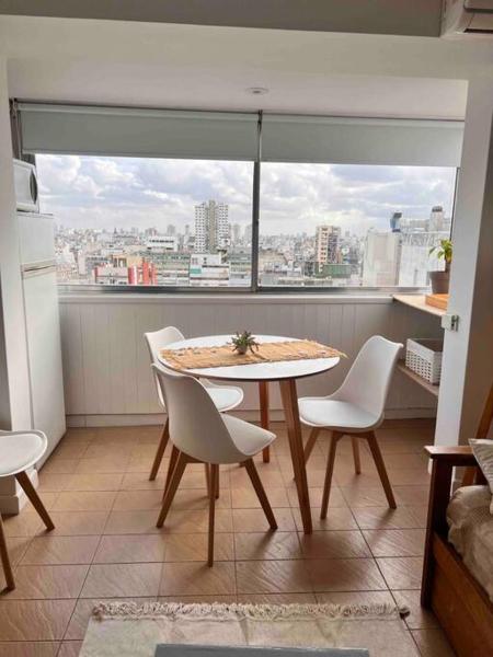una mesa y sillas en una cocina con una gran ventana en Excelente apartamento en zona centrica de Bs As en Buenos Aires