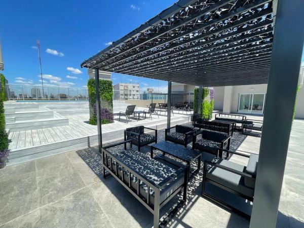 un grupo de bancos sentados bajo una pérgola en Hermoso departamento para 4 personas mejor zona Caballito 5J en Buenos Aires