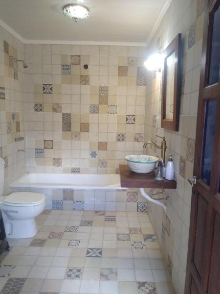 y baño con bañera, aseo y lavamanos. en La casita de Armi en Gualeguaychú