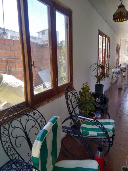 Habitación con sillas, mesa y ventanas. en La casita de Armi en Gualeguaychú
