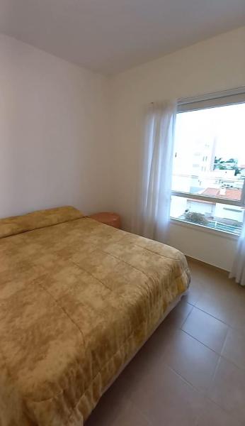 Un dormitorio con una cama grande y una ventana en 9 De Julio 345 en Puerto Madryn