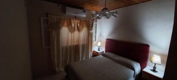 1 dormitorio con 1 cama y una ventana con 2 lámparas en YVAGA en Puerto Iguazú