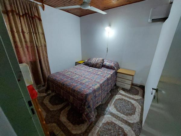 Habitación pequeña con cama y mesita de noche en Alquiler Temporario en Puerto Iguazú en Puerto Iguazú