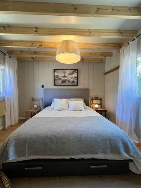 Un dormitorio con una cama grande y una lámpara de araña. en el ranchito en San Martín de los Andes