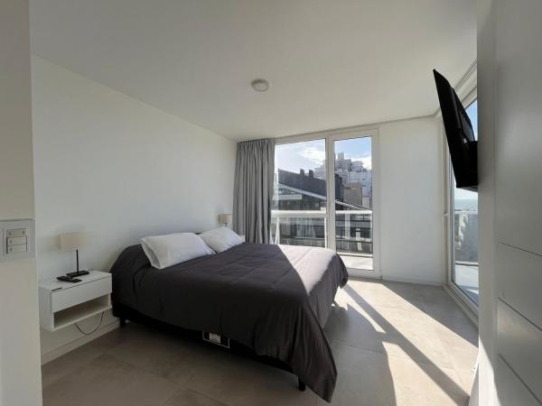 1 dormitorio con cama y ventana grande en Espectacular Departamento Premium en Playa Grande frente al mar en Mar del Plata