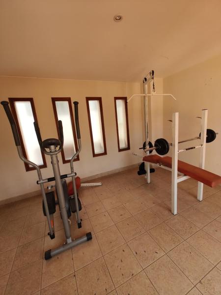 una habitación con un gimnasio con pesas y equipos de ejercicios en HERMOSO DEPARTAMENTO CENTRICO en Salta