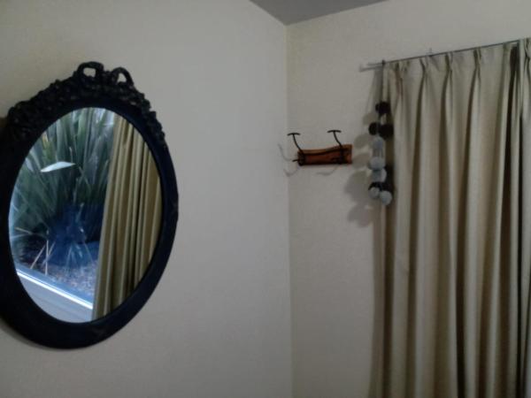 un espejo colgado en una pared junto a una ventana en Alegra Centro en San Martín de los Andes