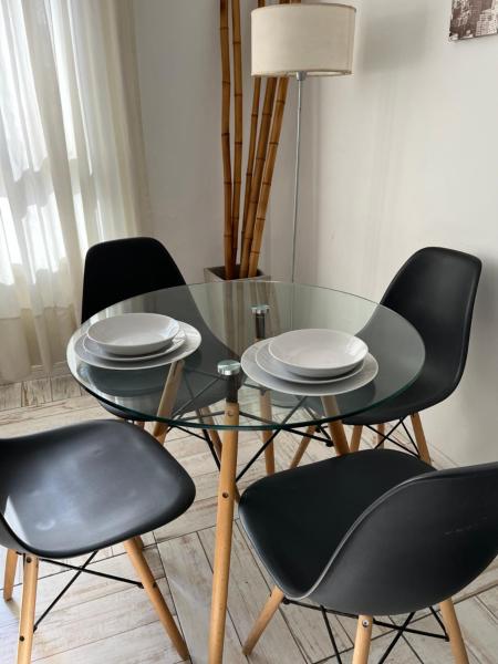 una mesa con 4 sillas y una mesa de cristal con platos. en Center Apartment Studio en Buenos Aires