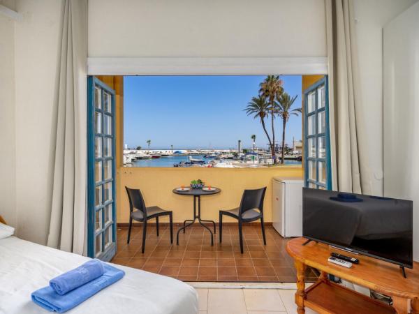 1 dormitorio con 1 cama y balcón con mesa y sillas en Studio Cabopino-2 by Interhome, en Marbella