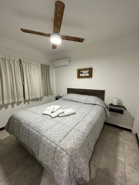 1 dormitorio con 1 cama con 2 toallas en Complejo CHACARERO Departamentos en Balneario Mar Azul
