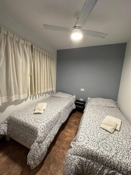 2 camas en una habitación con ventana a Complejo CHACARERO Departamentos en Balneario Mar Azul