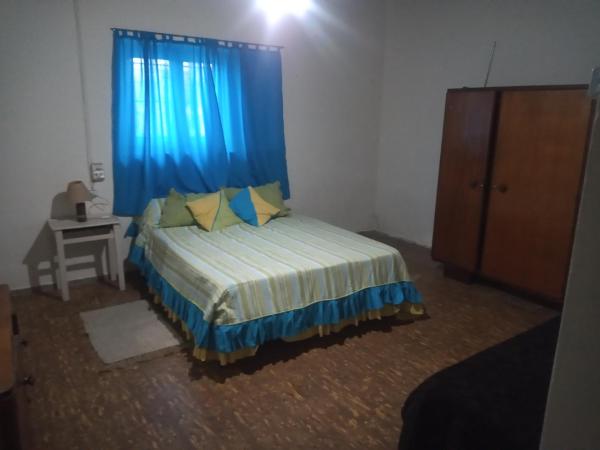 1 dormitorio con 1 cama con cortina azul en Casita de mis viejos en Mendoza
