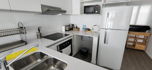 cocina blanca con refrigerador y fregadero en Apartamento Blanco con balcón en Buenos Aires