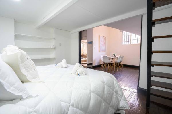 Un dormitorio con una gran cama blanca y una mesa en FRIENDS BUENOS AIRES- CAPITAL en Buenos Aires
