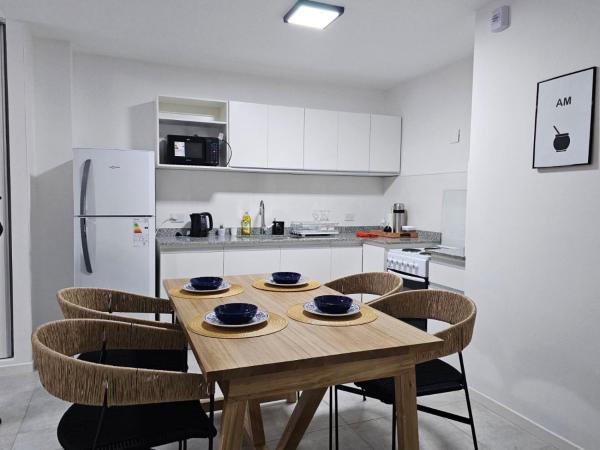 cocina con mesa de madera con sillas y refrigerador en Departamento de categoría en Salta Capital en Salta