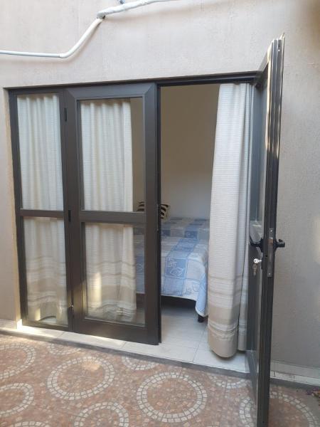 Una puerta corredera de cristal con una cama en una habitación en valdivia oeste 219 en San Juan