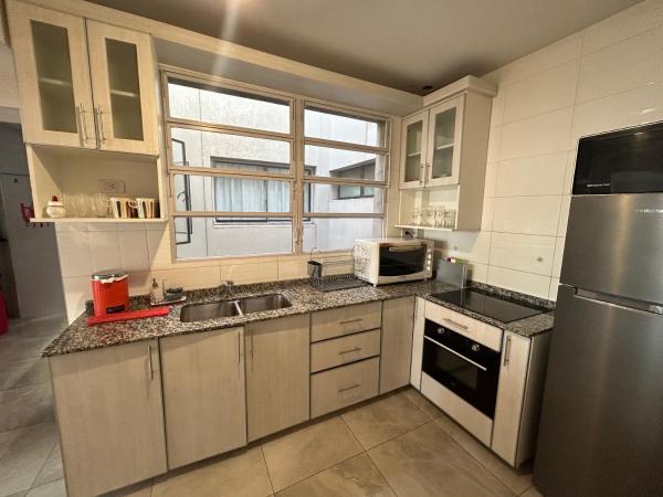 una cocina con electrodomésticos de acero inoxidable y una ventana en Depto Céntrico a Estrenar con cochera propia en Mendoza