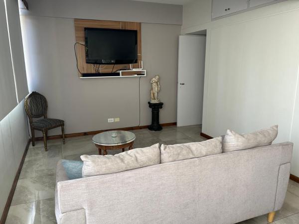 sala de estar con sofá y TV en Depto Céntrico a Estrenar con cochera propia en Mendoza