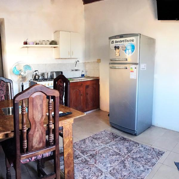 cocina con refrigerador y mesa. en Alojamiento Gonzalez Paz en Puerto Madryn