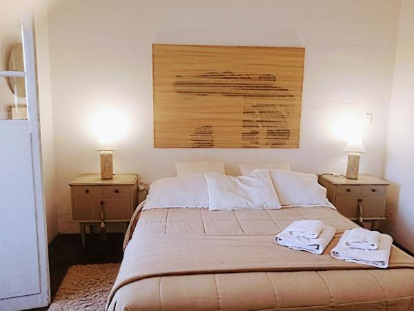 1 dormitorio con 2 mesitas de noche y 1 cama con 2 lámparas en CASA ARISTIDES en Mendoza