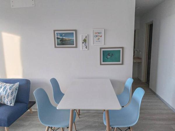 una mesa blanca y sillas azules en una habitación en Luminoso departamento a una cuadra del mar Puerto Madryn en Puerto Madryn