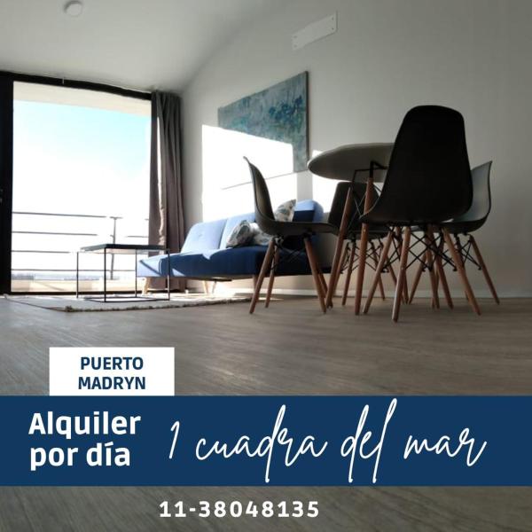 1 dormitorio con 2 sillas, 1 cama y 1 mesa en Luminoso departamento a una cuadra del mar Puerto Madryn en Puerto Madryn