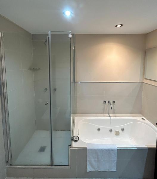 y baño con ducha, bañera y ducha. en Comfortable Modern Apartment en Buenos Aires