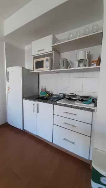 cocina con armarios blancos y refrigerador blanca en Departamento acogedor. en Buenos Aires